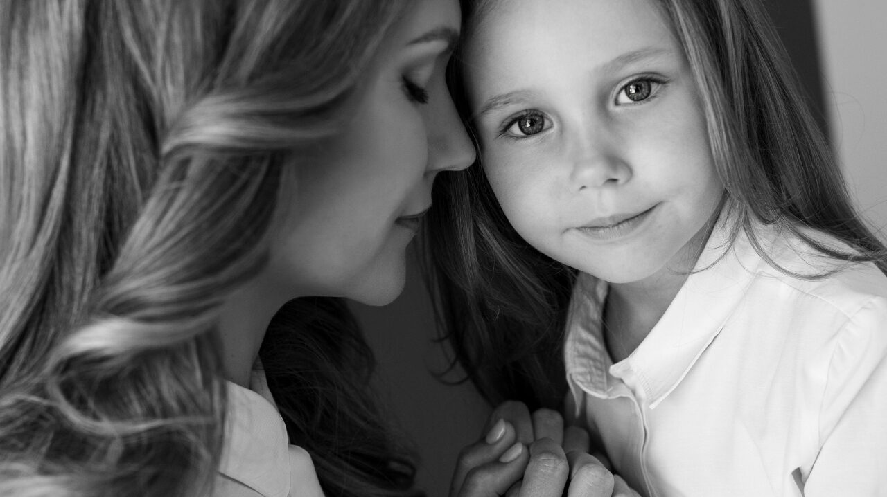 A mother resting her forehead against her daughter's